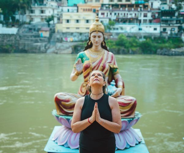 Person meditating peacefully outdoors with a serene natural background.